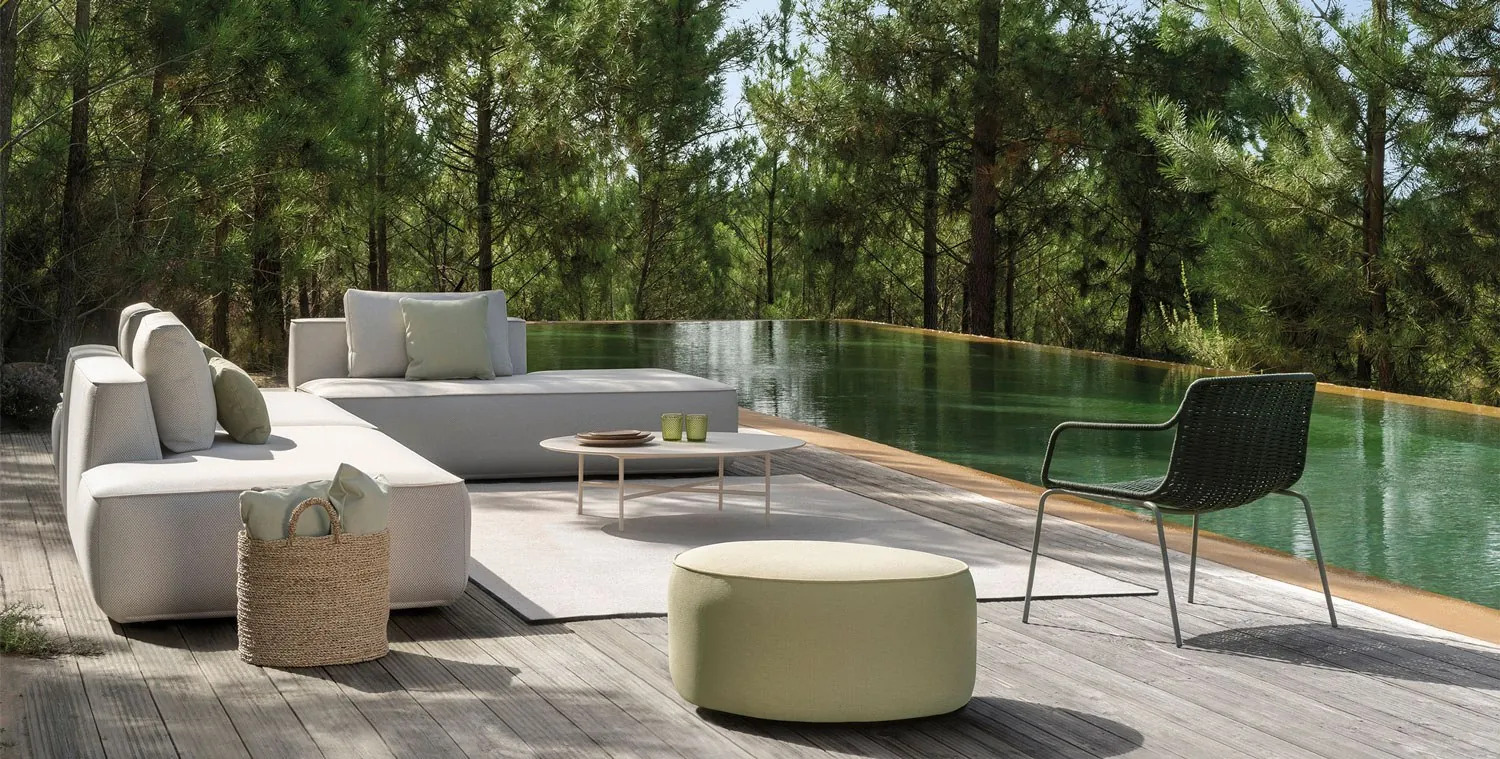 Sofá modular Plump junto a una piscina en un pinar.