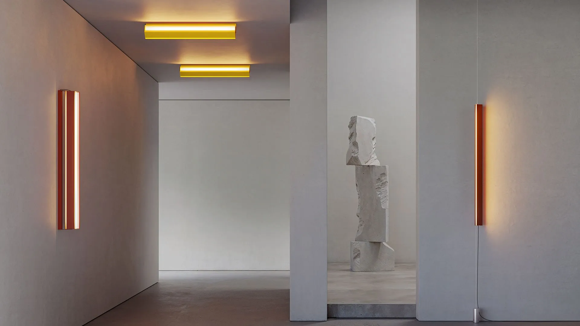 Luminarias Stripe de pared y techo en una sala con una escultura