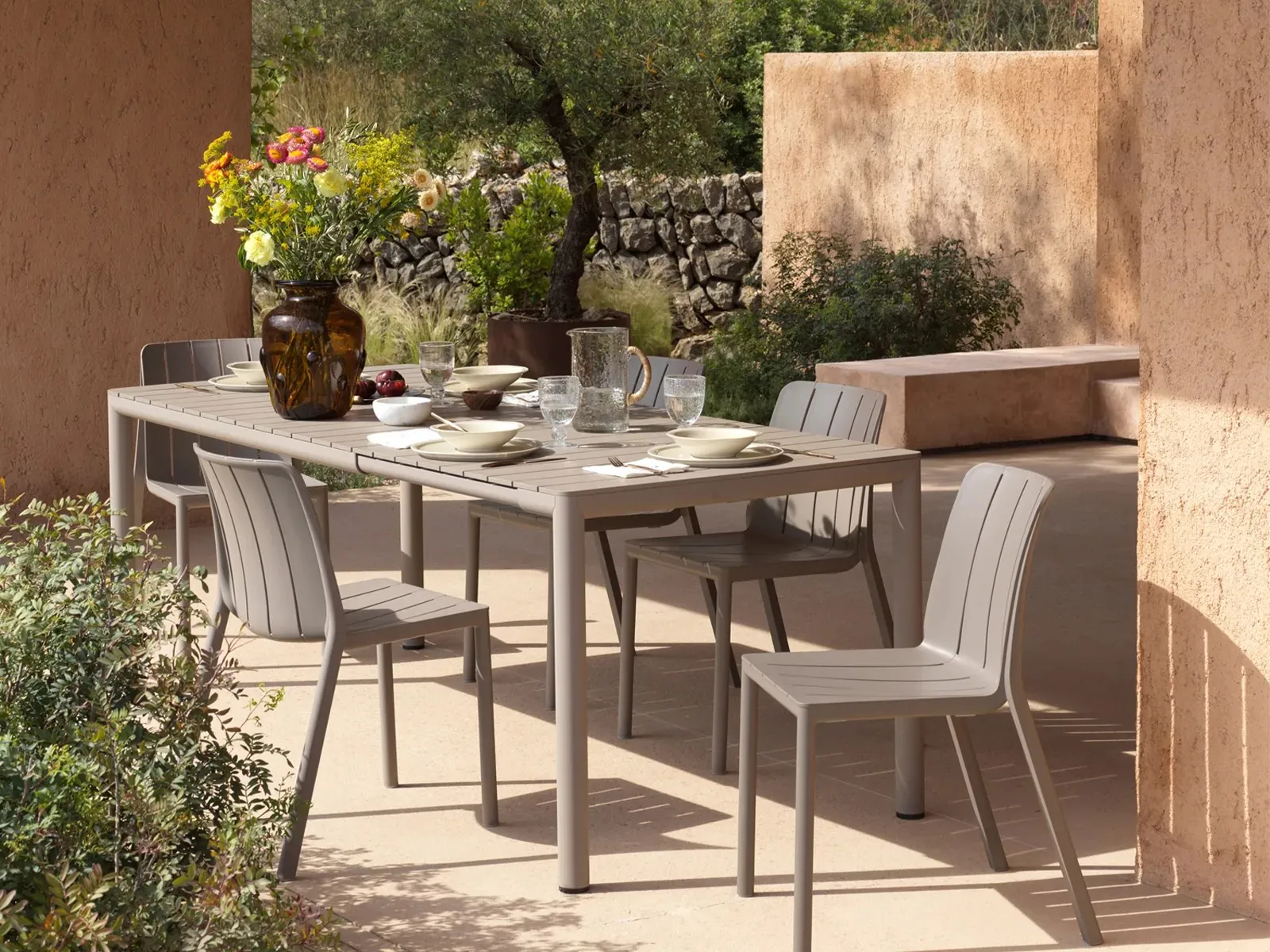 Nardi: mesa de comedor y sillas bajo un olivo